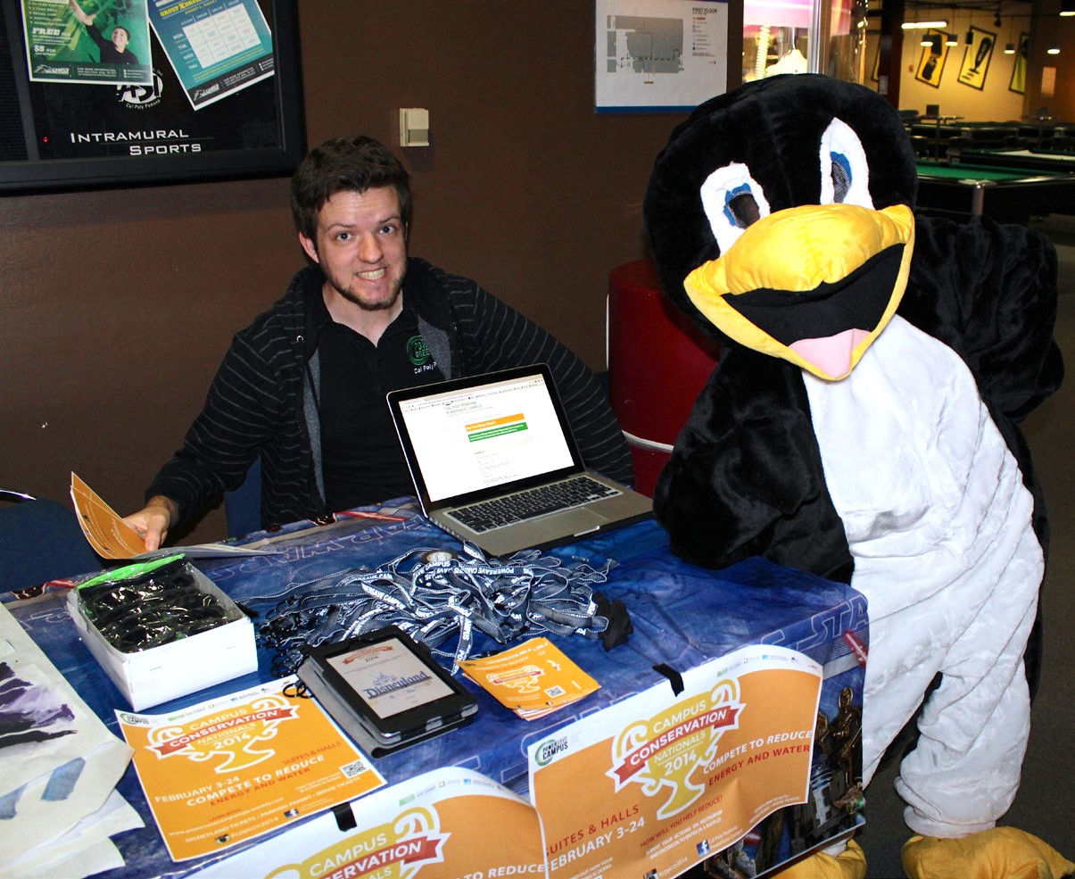 Cal Poly Pomona intern Brandon Sauer posing with another intern wearing the team's PowerSave mascot, Penny the Penguin, during a tabling event for a national energy savings competition called Campus Conservation Nationals (CCN)