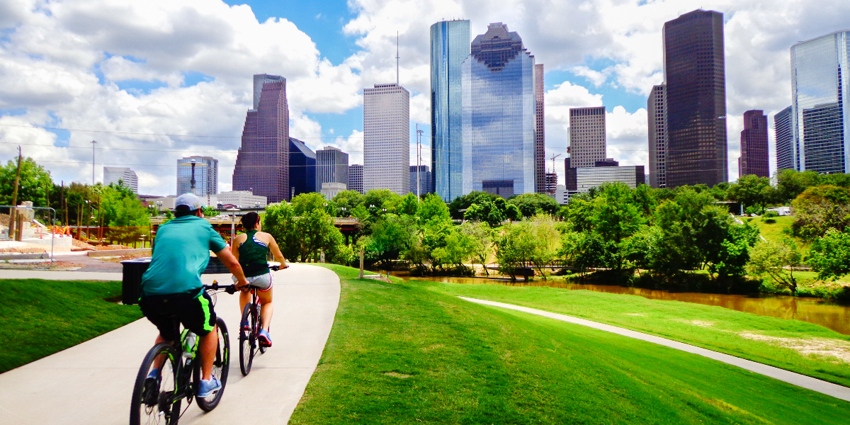 Cyclists ride past a city