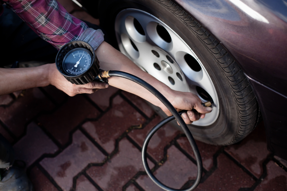 Driver checking tire pressure