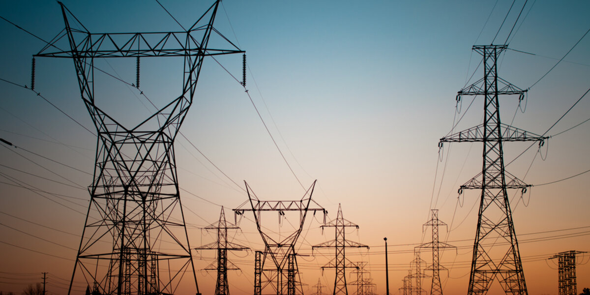 A long line of electrical transmission towers carrying high voltage energy.